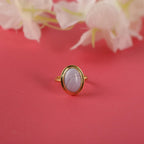 Gold ring with a blue lace agate on a red background with flowers