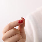 Hand holding a small stud earring with a pink tourmaline gemstone