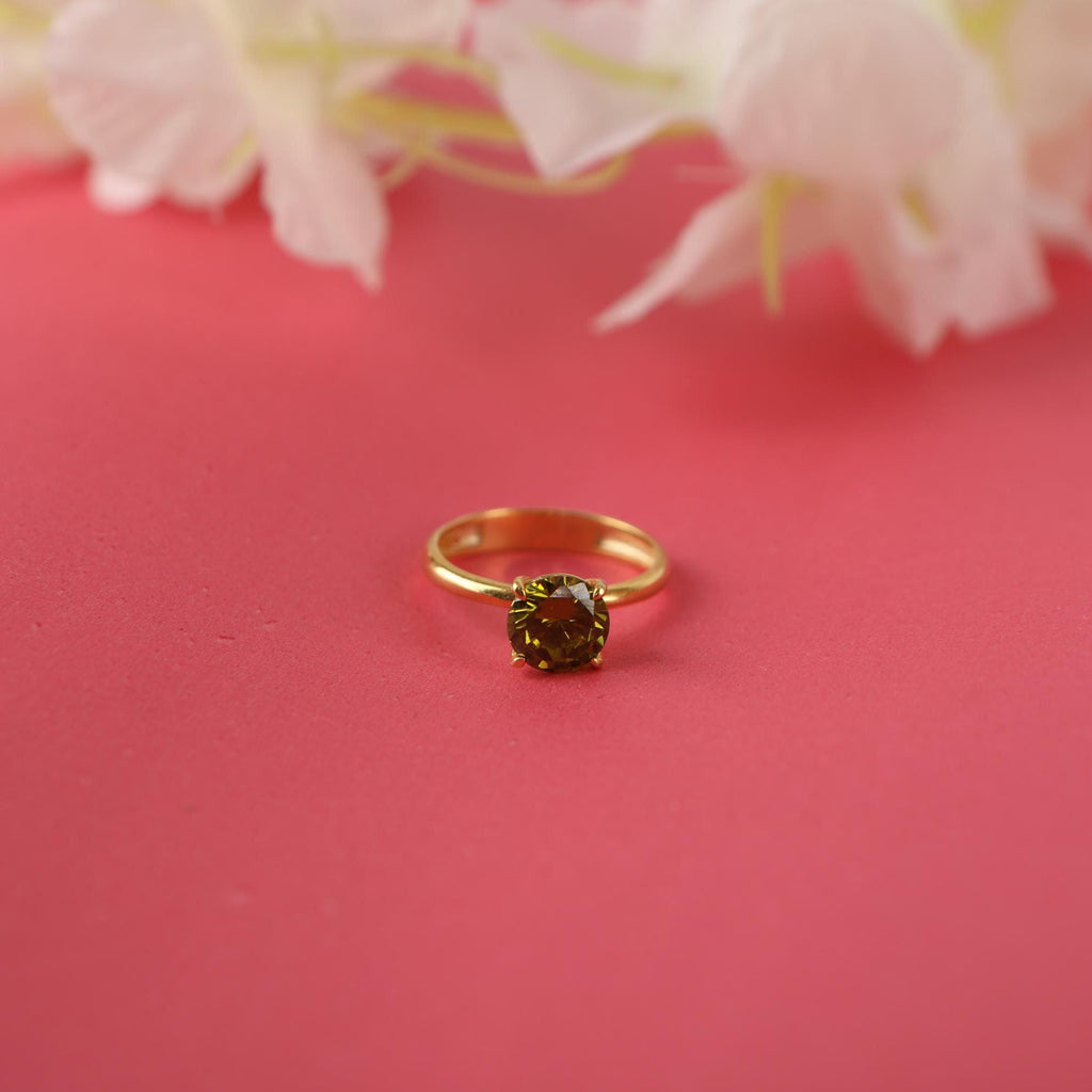 Gold ring with a gemstone on a pink background with flowers
