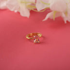 Gold ring with a pink gemstone on a red background with flowers