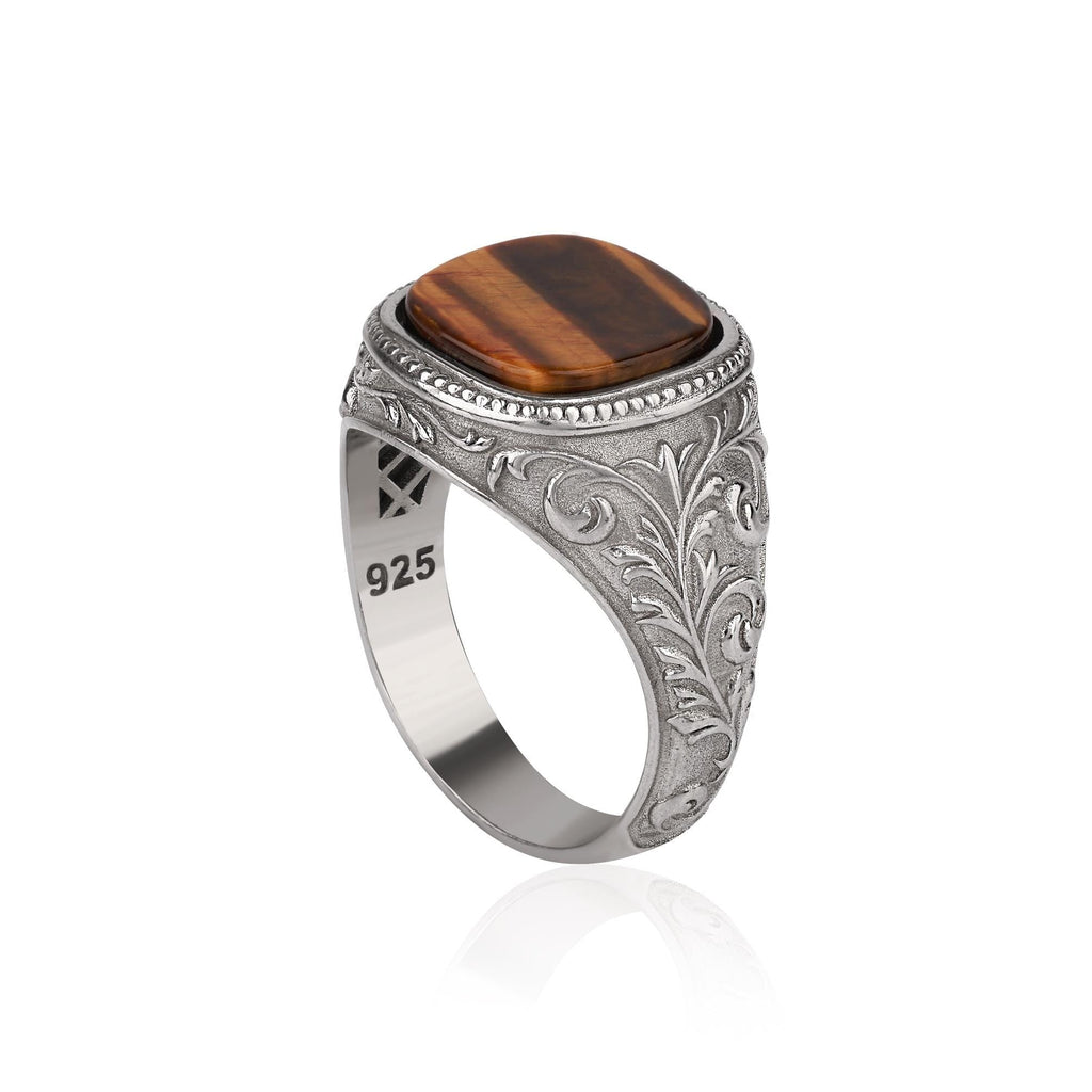 Silver ring with a cushion cut tiger's eye on a white background