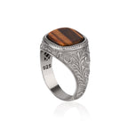 Silver ring with a cushion cut tiger's eye on a white background