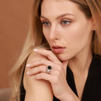 Woman wearing a black gemstone ring  with a neutral background