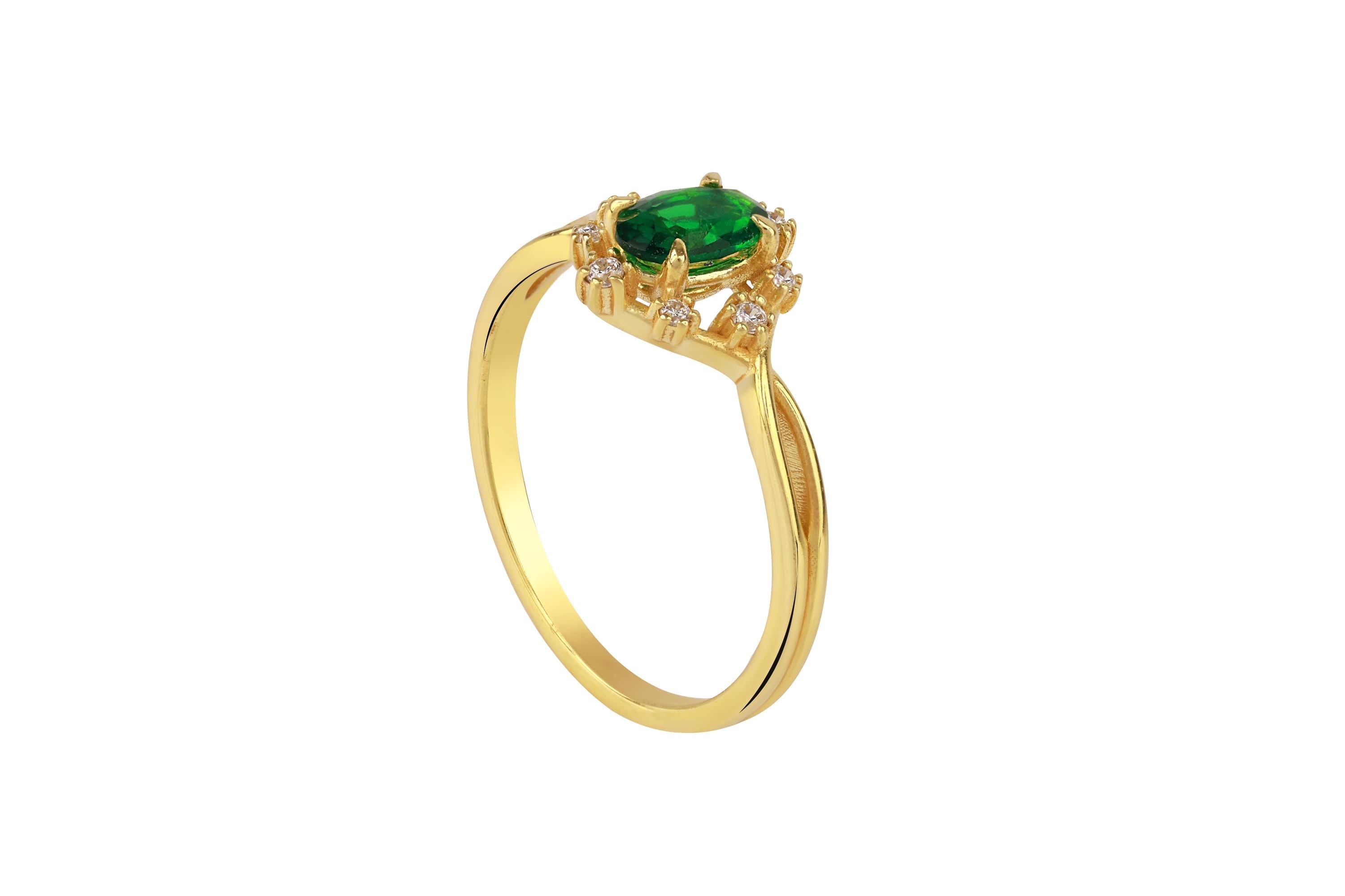 Gold ring with a green gemstone on a white background