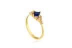 Gold ring with a blue gemstone on a white background