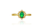 Gold ring with a green gemstone on a white background