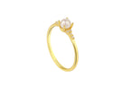 Gold ring with a pearl on a white background