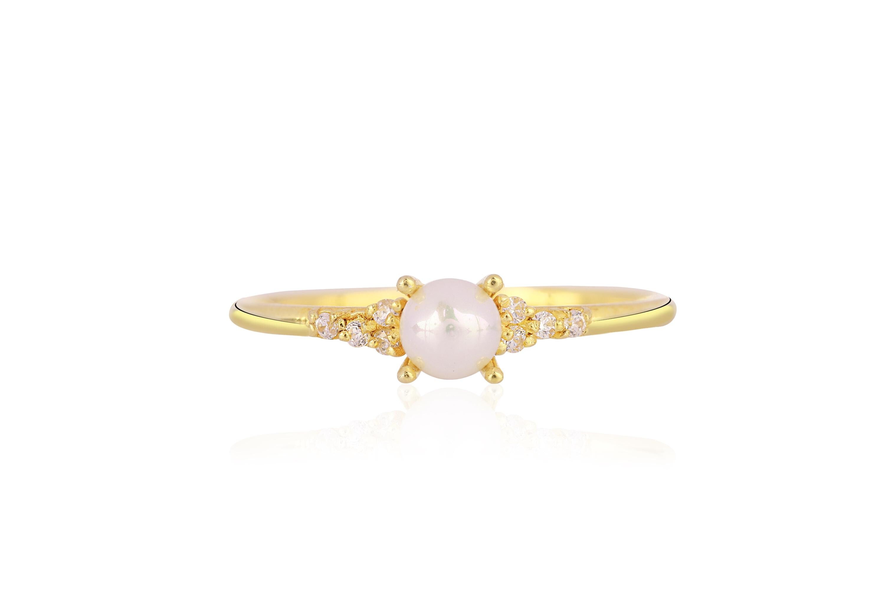 Gold ring with a pearl and small diamonds on a white background