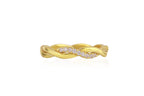 Gold rope ring with interwoven design on a white background