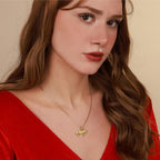 Woman wearing a gold necklace with a lion pendant against a beige background