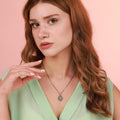 Woman wearing a religious necklace against a pink background