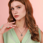 Woman wearing a religious necklace against a pink background