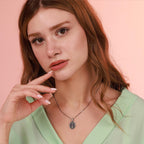 Woman wearing a Virgin Mary necklace with a pink background
