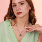 Woman wearing a st benedict coin necklace with a pink background