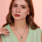 A woman wearing a jesus necklace with a pink background