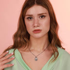 Woman wearing an Our Lady of fatima necklace with a pink background