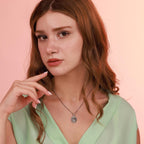 Woman wearing a St jude pendant necklace against a pink background