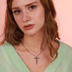 A woman wearing an oxidized sterling silver catholic cross necklace 