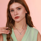Woman wearing an origami lion necklace with a pink background