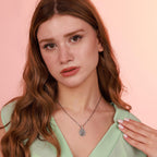 Woman wearing a religious necklace against a pink background