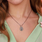 Necklace with a nativity scene pendant worn by a person with green top