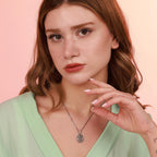 A woman wearing a religious necklace with a pink background