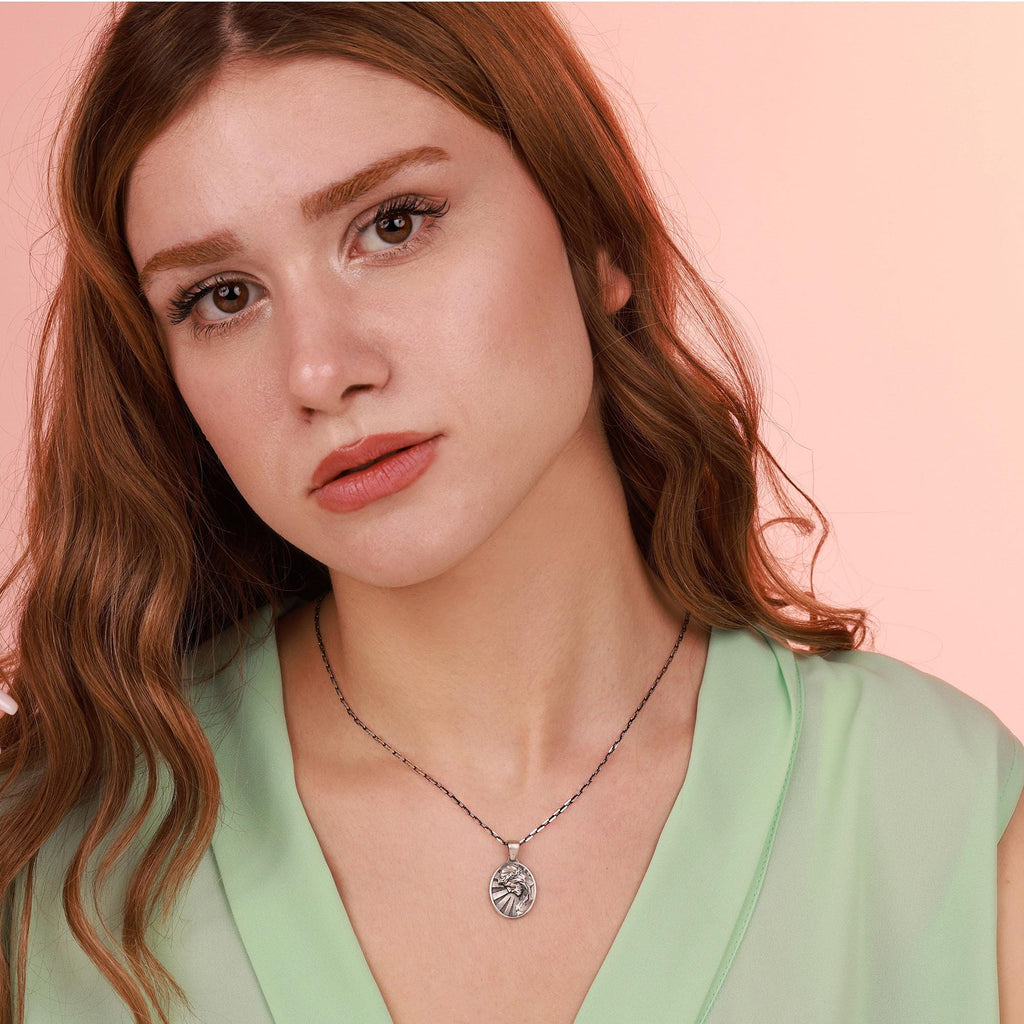 Woman wearing a jesus necklace with a pink background