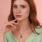 Woman wearing a resurrection jesus necklace with a pink background