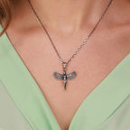 Necklace with a isis pendant worn by a person against a light green background