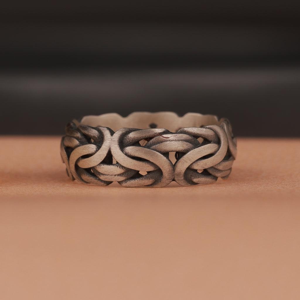 An oxidized silver ring on brown and dark background