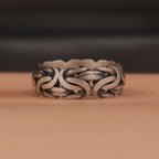 An oxidized silver ring on brown and dark background